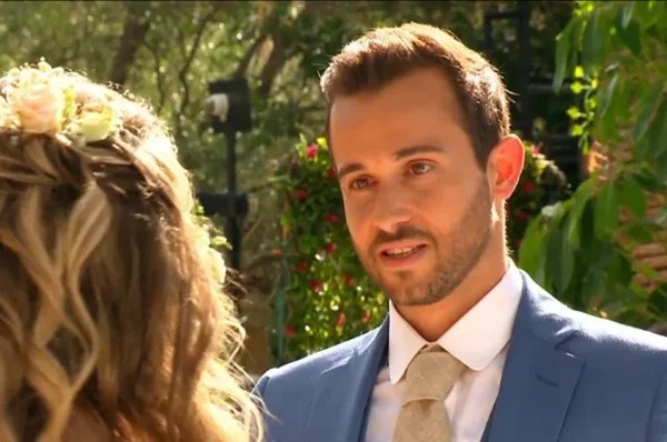 Antoine et Mélanie assis sur un lit, échangeant un regard.