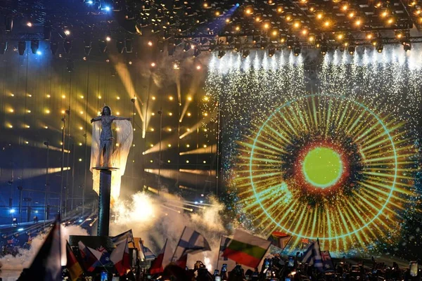 La scène de l'Eurovision 2026 avec effets pyrotechniques et le public agitant des drapeaux.