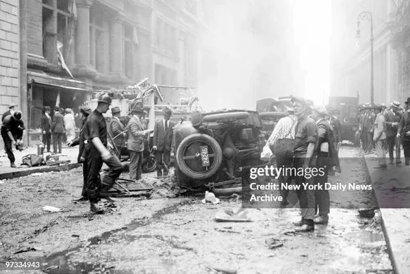 Conséquences de l'attentat de Wall Street en 1920 : un véhicule renversé entouré de pompiers et de policiers au milieu des débris.