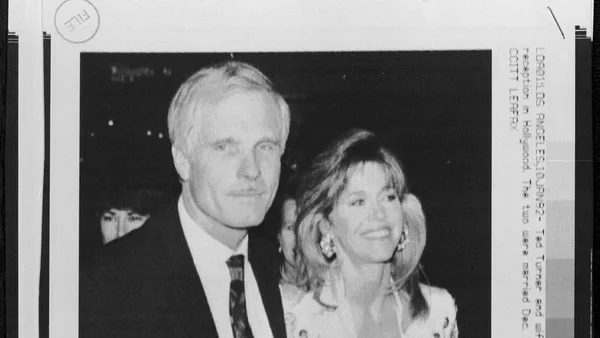 Ted Turner et une femme lors d'un événement, photographie d'archives en noir et blanc.