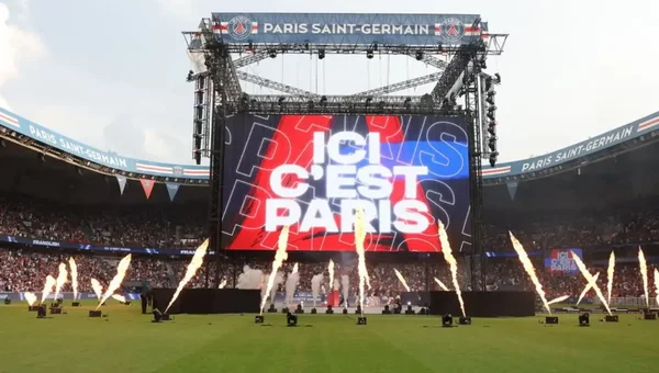Écran géant au Parc des Princes affichant 'ICI C'EST PARIS' avec pyrotechnie.