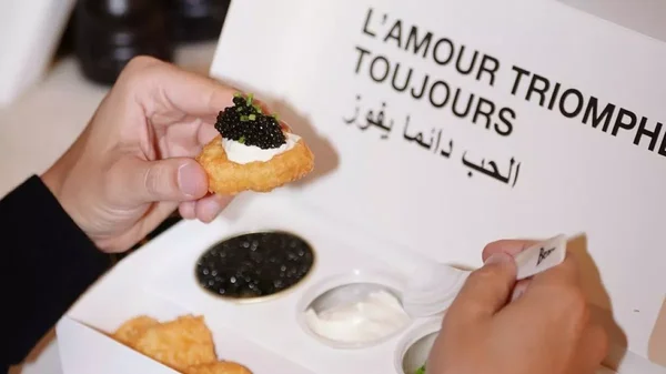 Un amuse-bouche signé Beau : chou à la crème et au caviar, présenté dans son packaging luxueux.