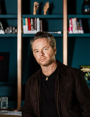 Noah Hawley, showrunner lauréat d'un Emmy, devant une bibliothèque.