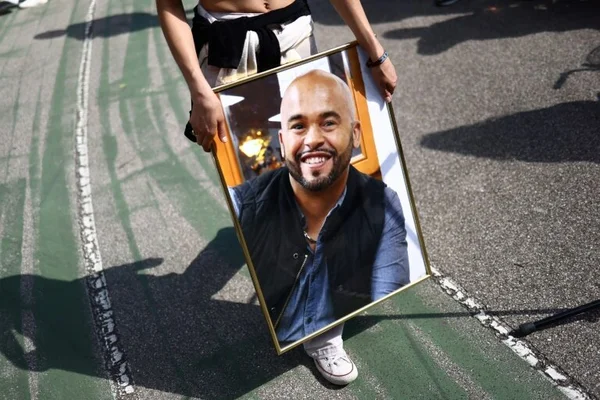 Hommage à un agent municipal tué à Grenoble, son portrait tenu lors d'une cérémonie.