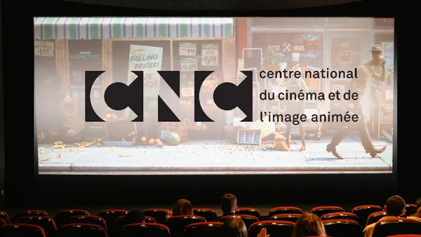 Le logo du CNC projeté sur un écran de cinéma devant un public.
