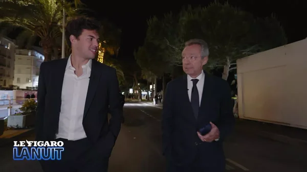 Deux hommes en costume discutant dans une rue la nuit, avec un logo Le Figaro La Nuit.