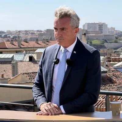 Stéphane Ravier sur un balcon avec vue sur Marseille.