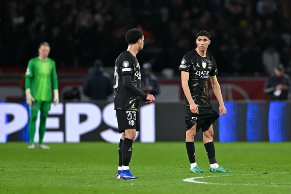 Joueurs du PSG en tenue extérieure noire lors d'un match.