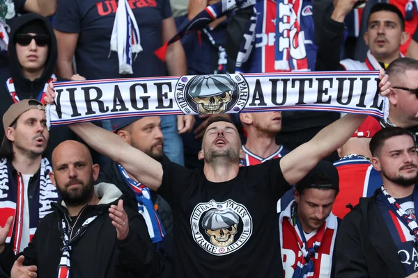 Supporters du PSG du groupe 'Virage Auteuil' célébrant dans le stade.