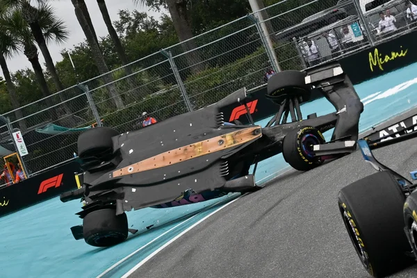 Monoplace de F1 retournée sur le toit lors du Grand Prix de Miami 2026, montrant des dégâts importants et des spectateurs assistant à la scène.