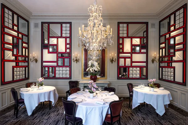 Le cadre raffiné du restaurant L'Ambroisie, décoré de miroirs rouges et d'un lustre en cristal.