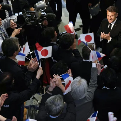 Emmanuel Macron applaudissant lors d'un événement franco-japonais à Tokyo.