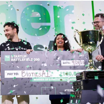 Les gagnants de Startup Battlefield 200, BioticsAI, célébrant avec un chèque de 100 000 dollars et un trophée.