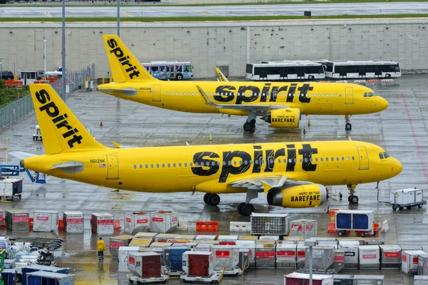 Deux appareils de Spirit Airlines stationnés sur le tarmac d'un aéroport.