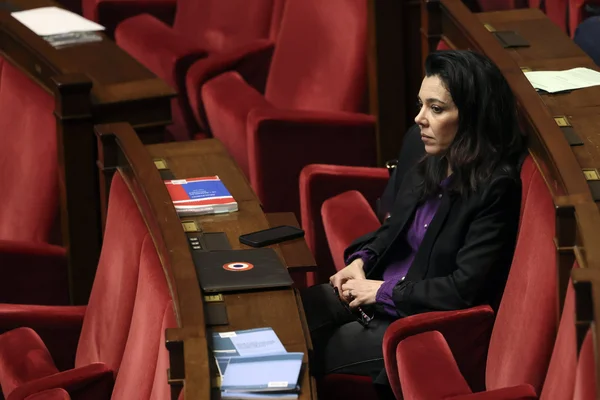 Sophia Chikirou dans l'hémicycle, assise dans un fauteuil rouge, veste noire et chemise violette.