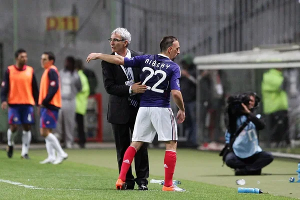 Raymond Domenech et Franck Ribéry côte à côte sur le terrain, entourés de l'équipe technique.