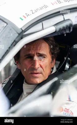 Alessandro Zanardi installé dans son cockpit, portant sa combinaison de course blanche.