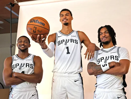 Trois joueurs des Spurs en portrait studio, dont Wembanyama au centre.