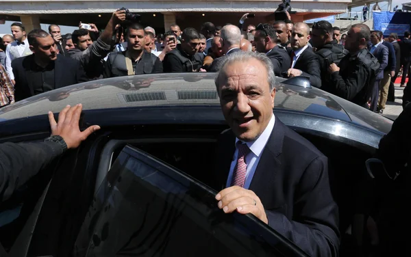 Yasser Abbas sortant d'une voiture noire, entouré d'une foule et de journalistes.