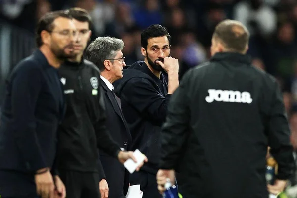 L'encadrement du Real Madrid sur le bord du terrain, avec un homme pensif au centre.