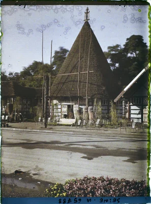 Le pavillon de la Nouvelle-Caledonie et dépendances à l'Exposition Coloniale de 1931. La photo est en couleurs, on y voit le pavillon, quelques statues.