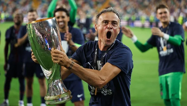 Luis Enrique célébrant avec ses coéquipiers après avoir remporté un trophée sur le terrain.