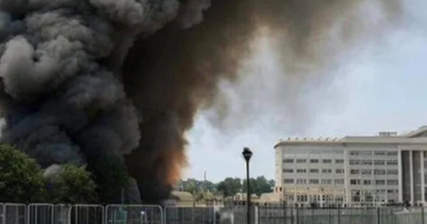 Image d'une explosion avec un important panache de fumée noire derrière un bâtiment blanc, dans le contexte de fausses informations ayant affecté Wall Street.