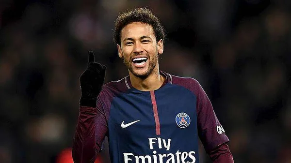 Neymar Jr. souriant et pointant le ciel sous le maillot du PSG.