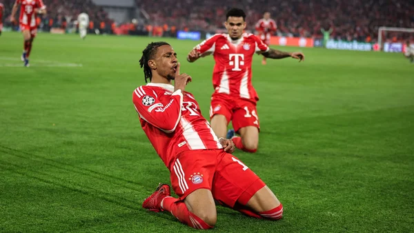 Un joueur du Bayern Munich effectue une célébration avec un geste de silence sur la pelouse de l'Allianz Arena.