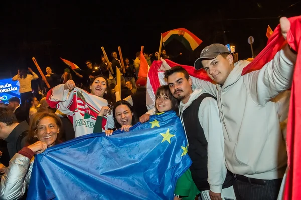 Des jeunes célèbrent dans la rue la défaite de Viktor Orbán, drapeaux européens en main.
