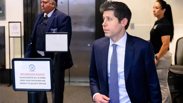 Sam Altman lors du procès OpenAI, filmé devant un panneau de sécurité.