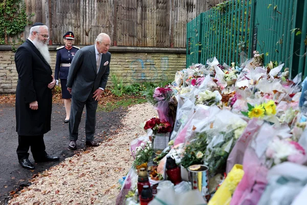 Le roi Charles III et un rabbin devant les hommages floraux déposés en mémoire des victimes d’attaques antisémites.