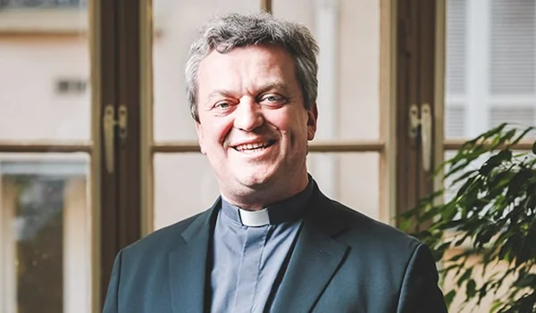 Benoist de Sinety, prêtre et auteur, souriant devant une fenêtre.