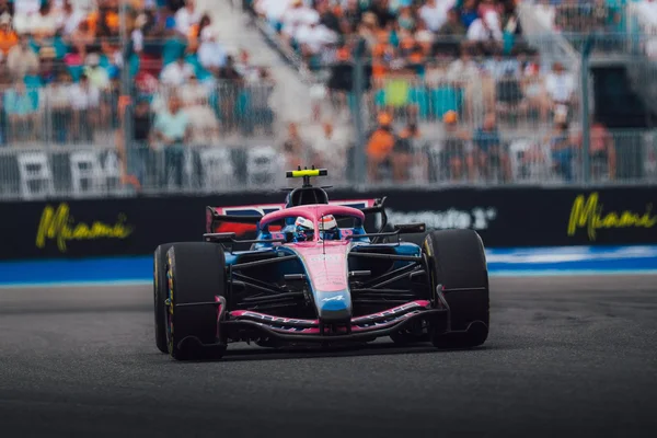 Monoplace Alpine de F1 en action au Grand Prix de Miami 2026, avec de la fumée et des spectateurs en arrière-plan.