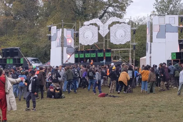 Une foule rassemblée devant une scène extérieure lors d'une rave party dans le Cher.