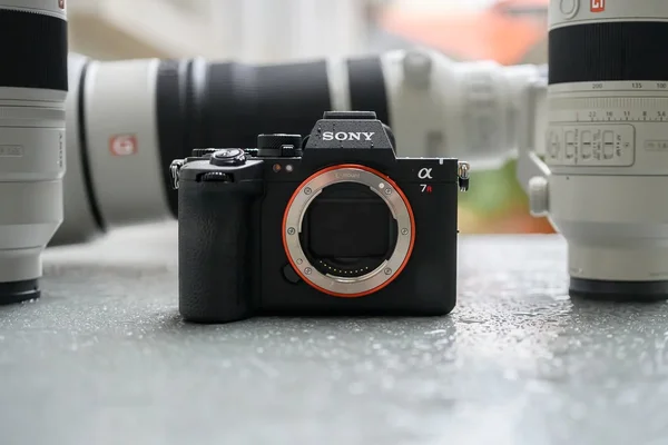Sony A7R VI entouré de téléobjectifs blancs.