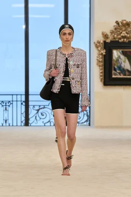 Un mannequin défilant à Biarritz pour Chanel Croisière 2027 avec les sandales réinventées sans semelle.