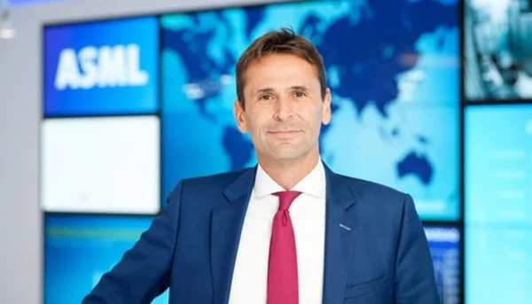 Christophe Fouquet posant devant une installation numérique aux couleurs d'ASML.