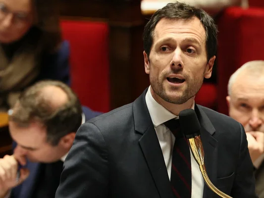Orateur s'adressant à l'assemblée dans un hémicycle.