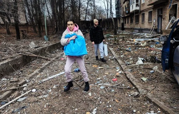 Femme traversant une zone dévastée par les frappes en Ukraine.