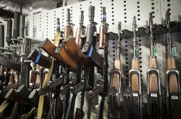 Fusils d'assaut de type AK saisis dans le Val-d'Oise, présentés dans un râtelier.