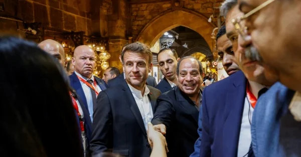 Emmanuel Macron serrant la main d'un interlocuteur lors de sa visite en Égypte.