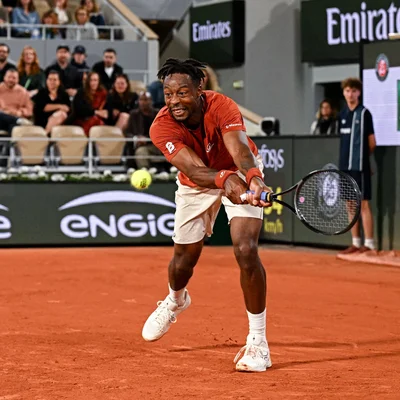 Gaël Monfils jouant un revers à Roland-Garros devant le public.