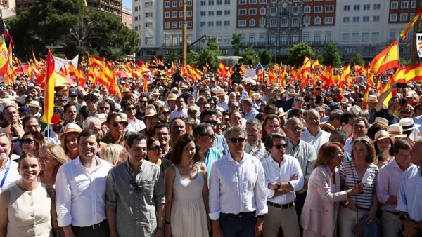 Des milliers de manifestants à Madrid, certains souriants, brandissant des drapeaux espagnols.