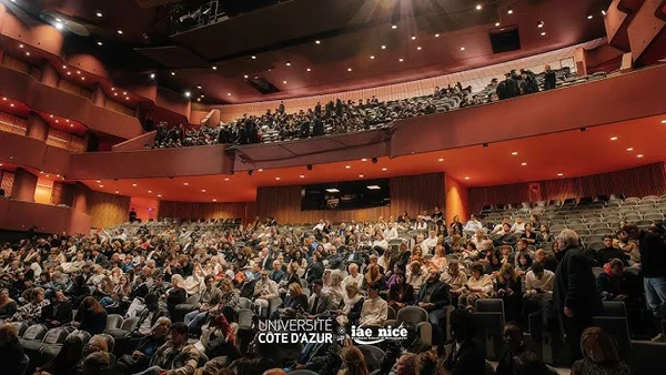 Assemblée nombreuse dans un auditorium moderne lors d'une cérémonie à l'Université Côte d'Azur.