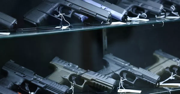 Des armes à feu exposées sur des étagères en verre dans le cadre d'une enquête sur un réseau de trafic d'armement.