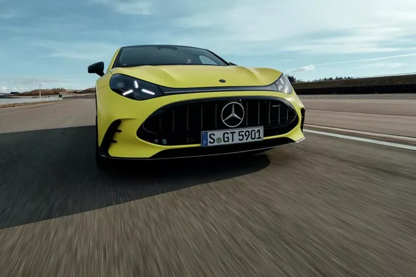 Mercedes-AMG GT jaune en pleine accélération sur piste, flou de mouvement.