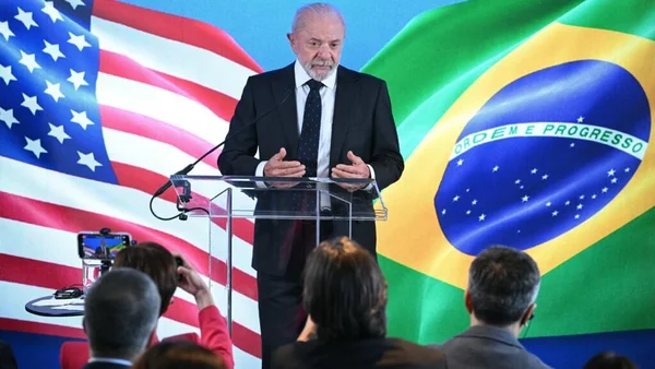 Lula s'adressant à la presse lors d'une conférence à la Maison Blanche, drapeaux américain et brésilien en toile de fond.