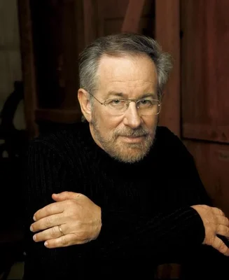Steven Spielberg en pull noir, les bras croisés.