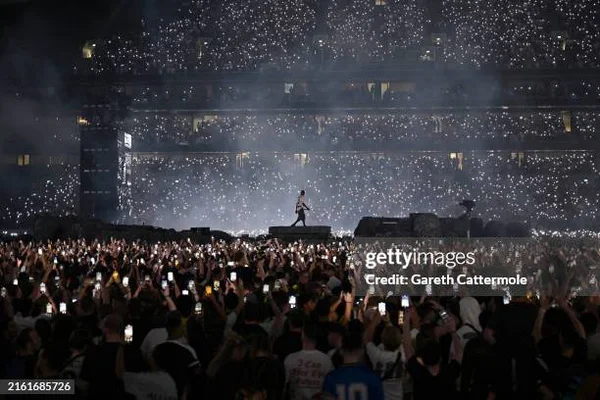 Foule de fans lors d'un concert de Travis Scott, créant une mer de lumières avec leurs téléphones.